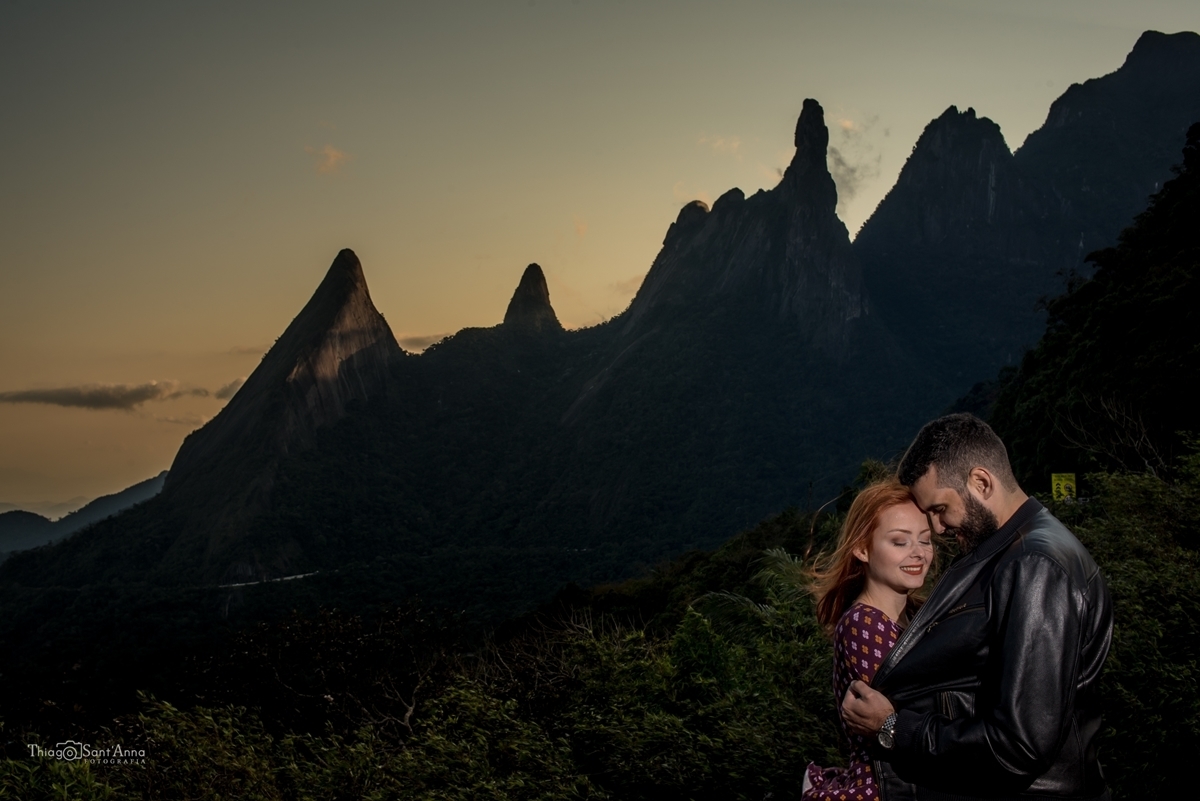 Fotografia de casal em ensaio pré-wedding no pôr do sol em frente ao dedo de Deus