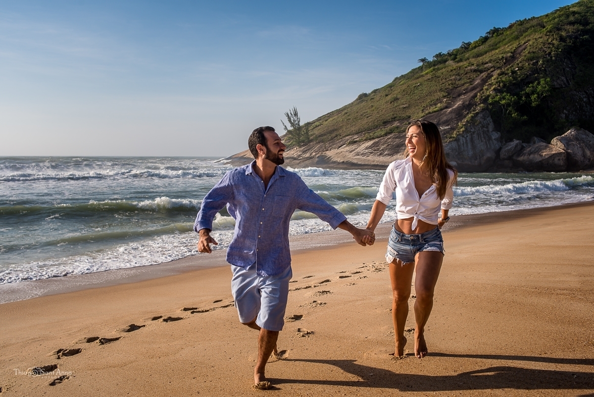 Fotografia de casal correndo a beira mar