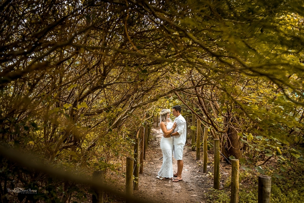 Fotografia de casal em ensaio pré casamento num caminho de terra na sombra das árvores