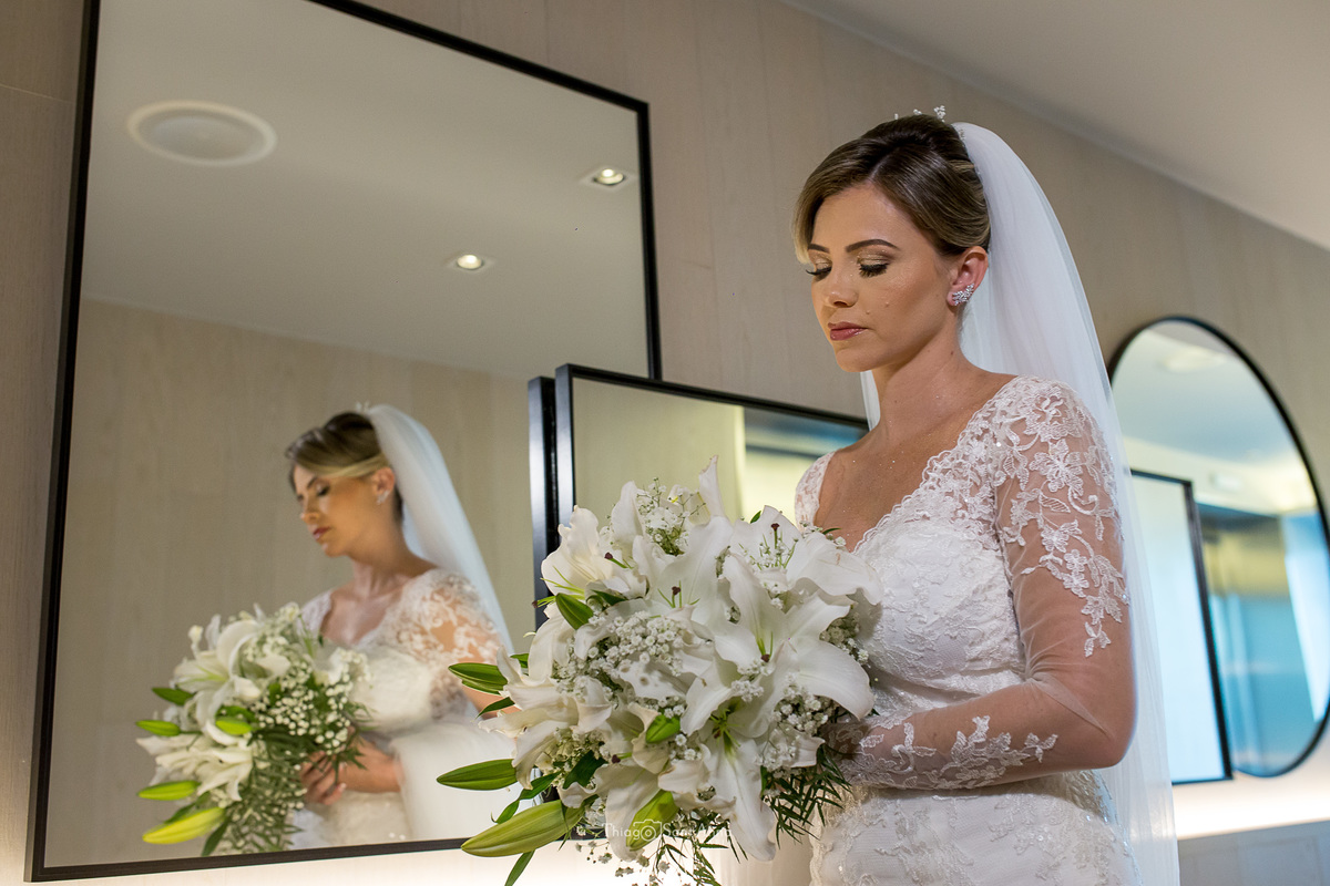 noiva vestido véu observa seu buque branco reflexo espelhos