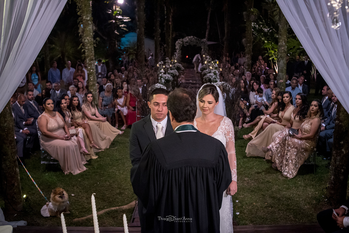 noivos no altar padrinhos e convidados ao fundo