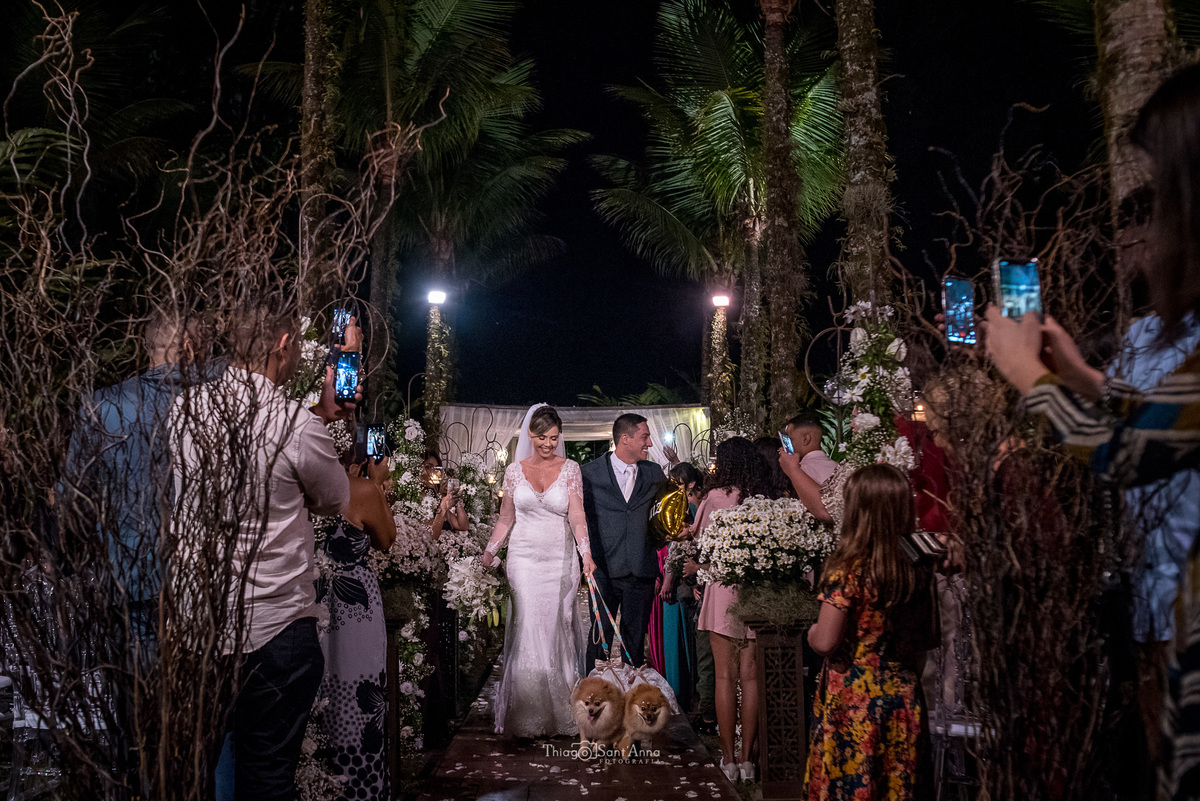 saída dos noivos fim da cerimônia pets convidados registam com celular decoração palmeiras flores brancas