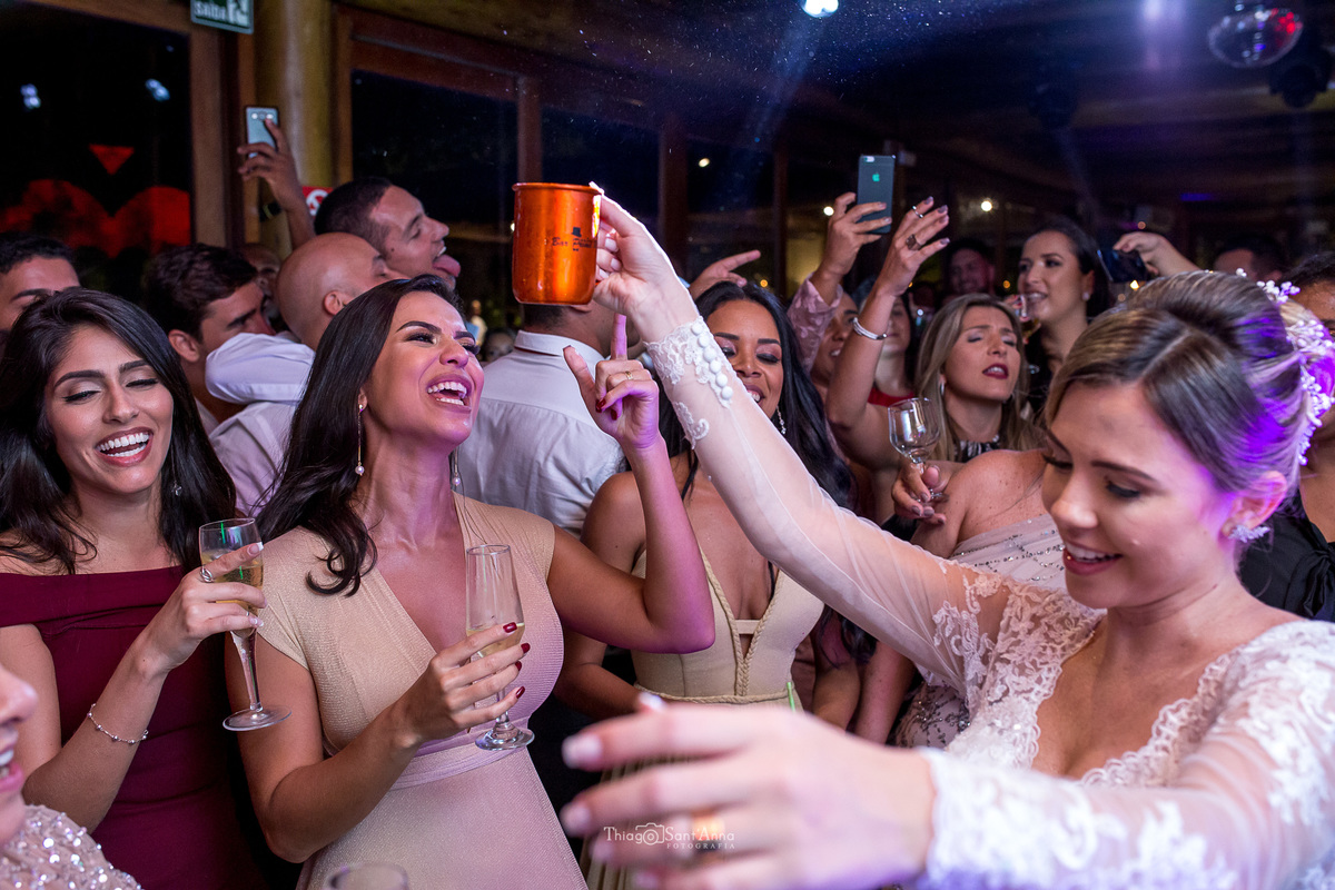 noiva sorri dança dança na pista junto a convidados e padrinhos 