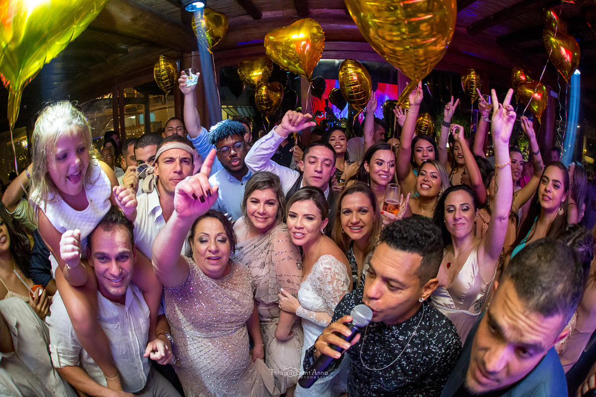 noivos e convidados pista de dança balões de coração cantor microfone