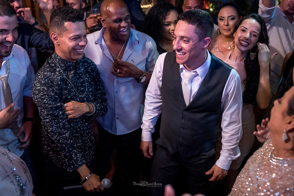 noivo sorri junto a padrinhos e cantor festa casamento