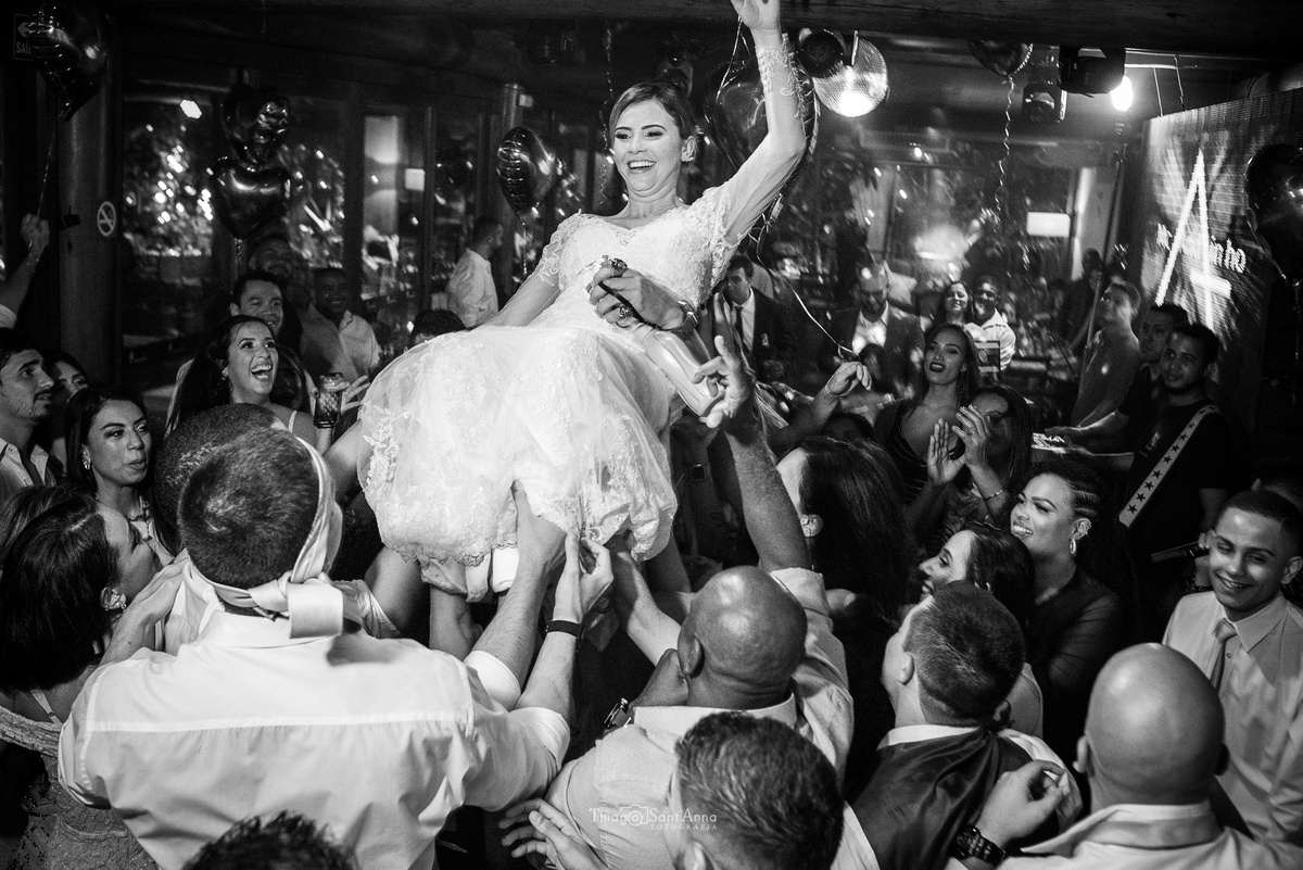 padrinhos levantam noiva nos ombros pista de dança preto e branco