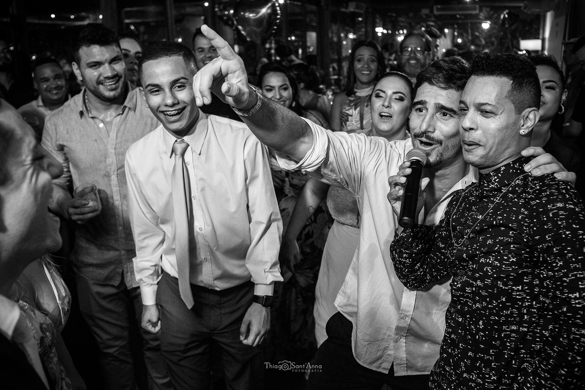 padrinho canta ao microfone junto a cantor padrinhos sorrindo preto e branco
