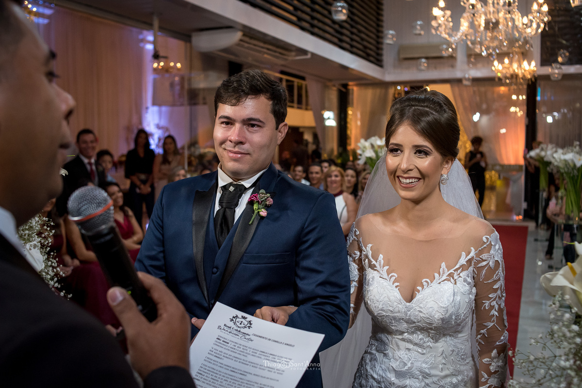 casamento cerimônia noivos ouvem o pastor decoração lustre convidados ao fundo