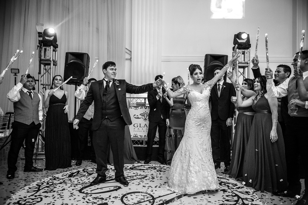 noivos dançam padrinhos seguram bastões luminosos preto e branco 