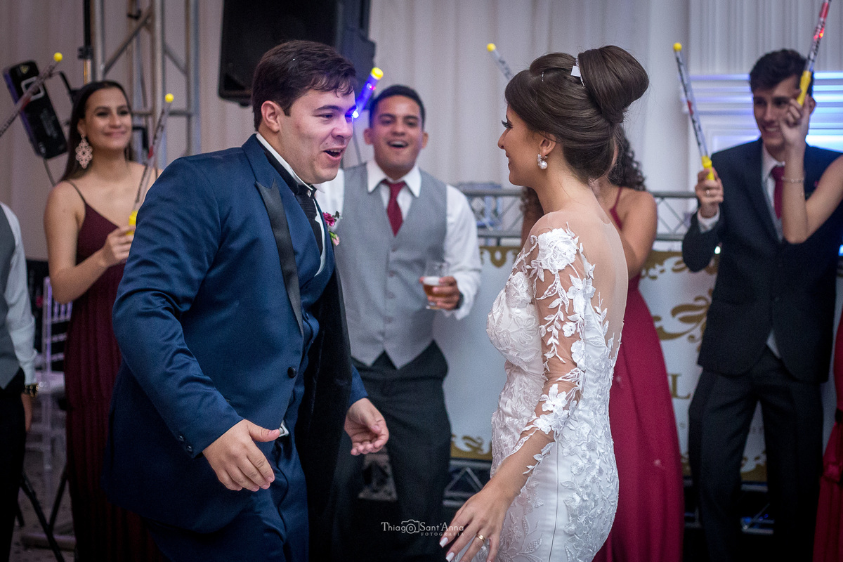 noivos dançam padrinhos seguram bastões luminosos 