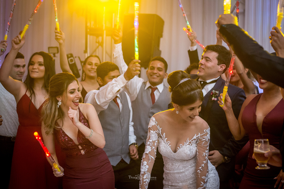noivos dançam padrinhos seguram bastões luminosos 