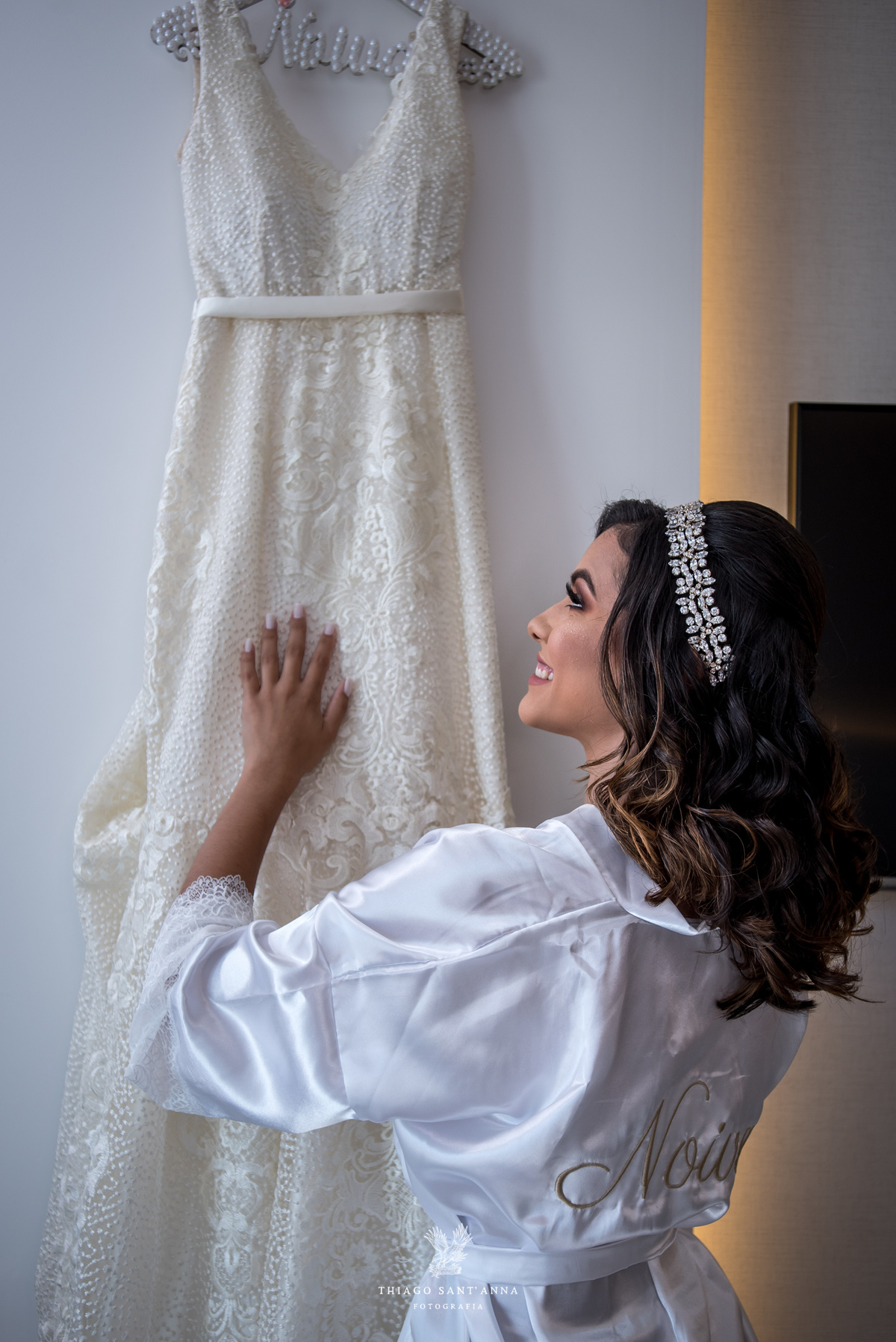 noiva sorri admirando seu vestido