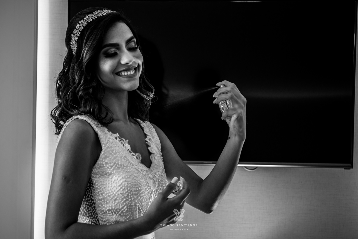 noiva se perfuma sorrindo preto e branco
