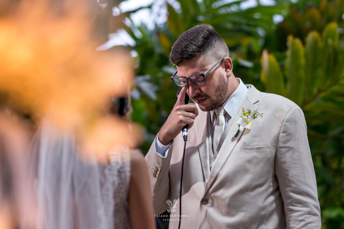 noivo emocionada enxuga lágrimas vegetação ao fundo