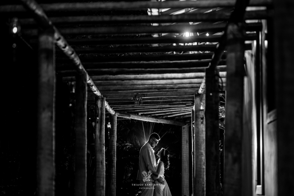 noivos posam abraçados caminho estrutura de madeira preto e branco