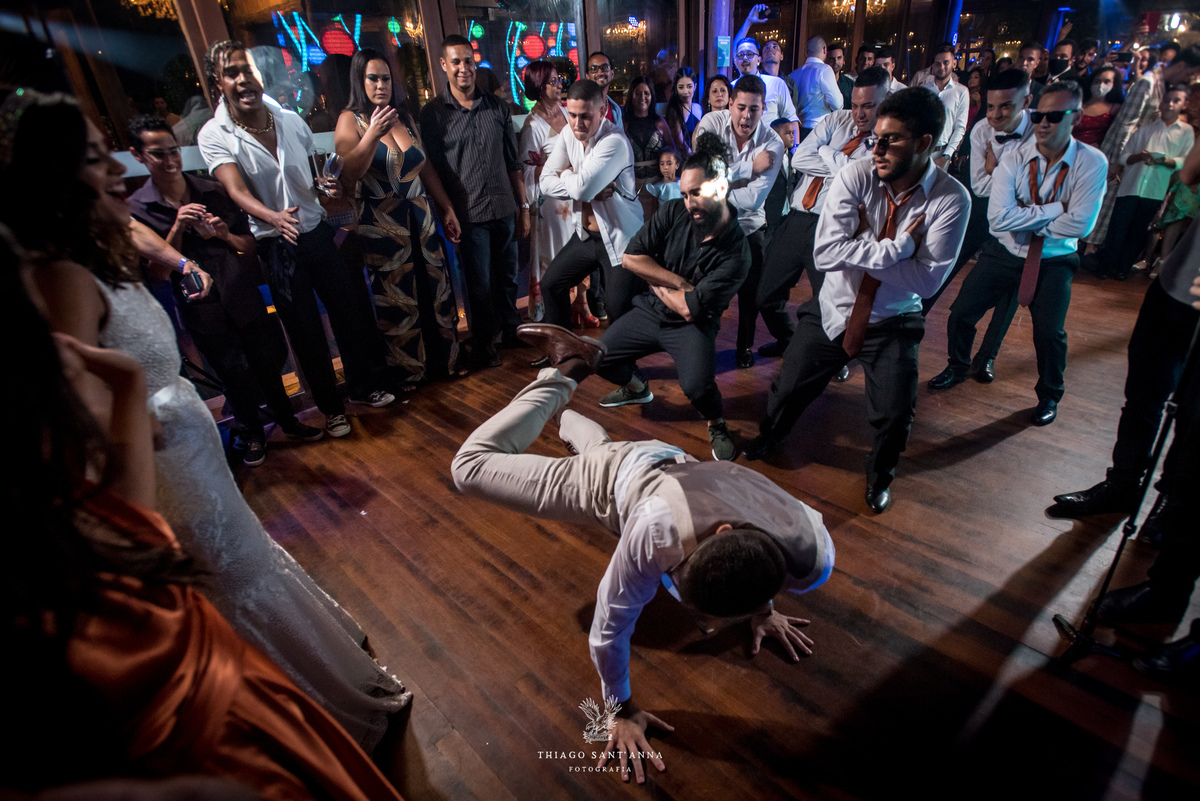 noivo dança na pista junto a padrinhos noiva madrinhas convidados observam