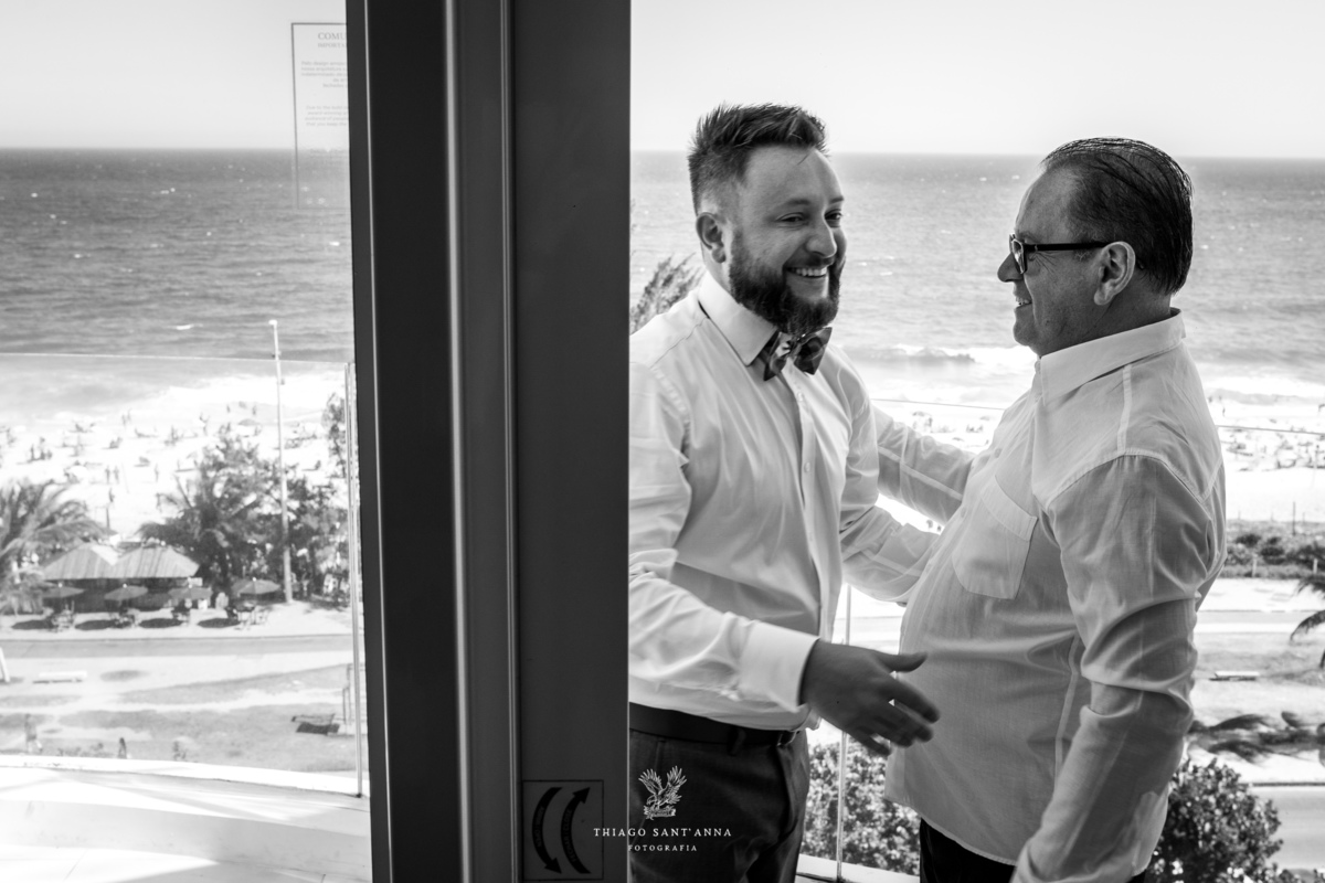 noivo abraça seu pai paisagem praia ao fundo preto e branco
