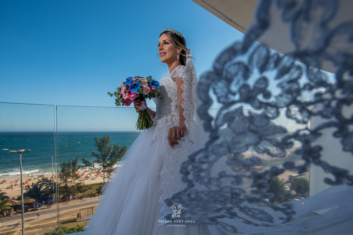 noiva observa paisagem renda vestido buque flores coloridas 