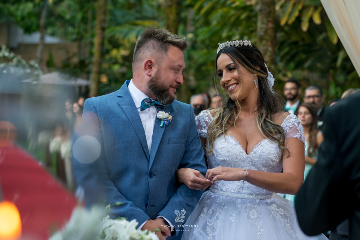 noivos sorrindo altar se observam vegetação ao fundo 