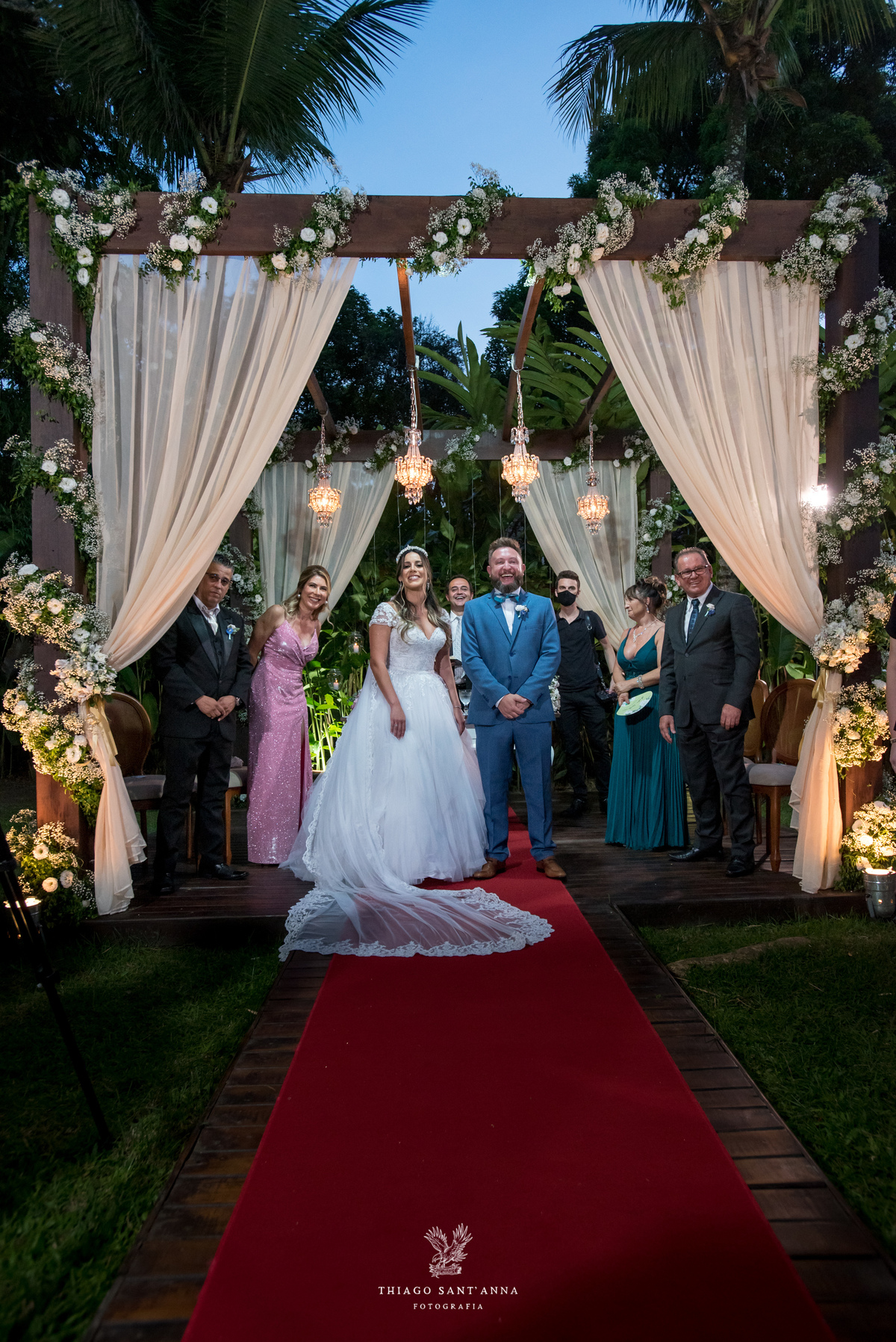 noivos no altar observam a chegada do pajem junto a familiares