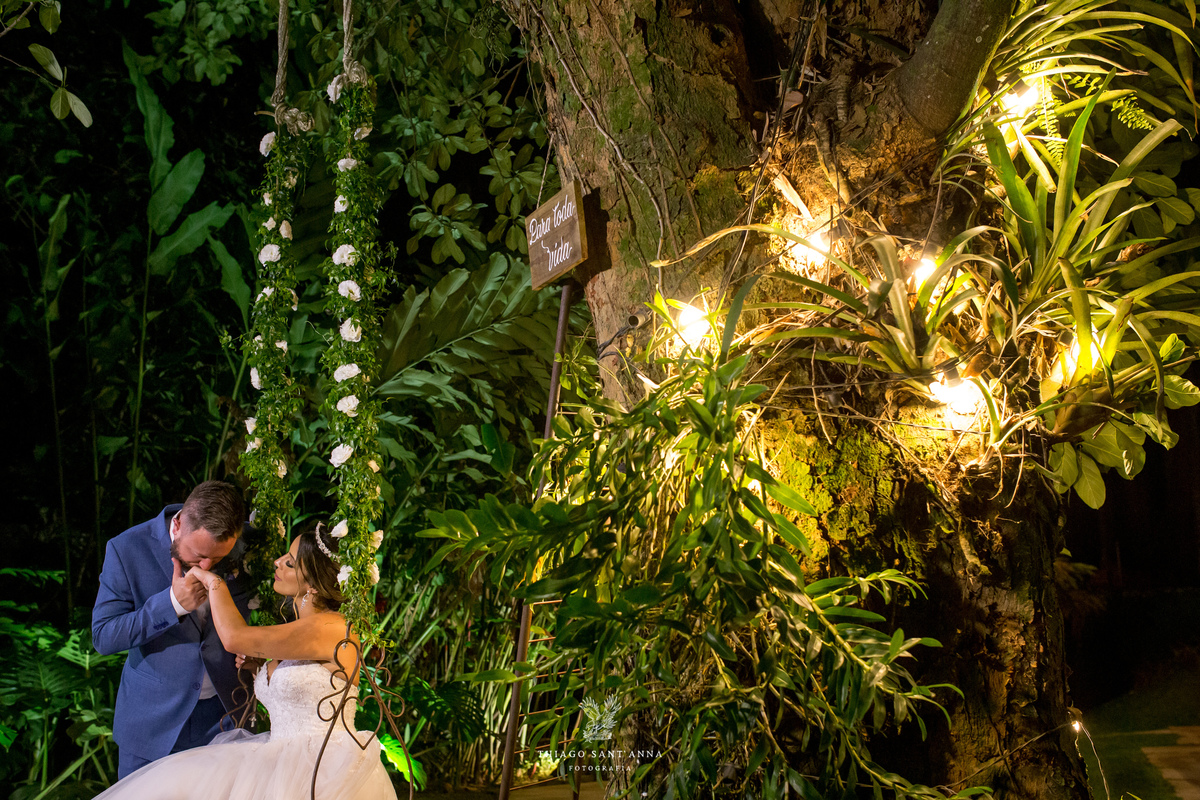 noiva sentada em balanço decorado vegetação flores brancas