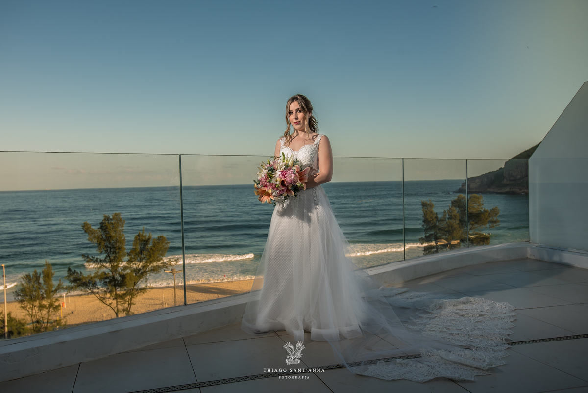 noiva vestido véu buque flores tons de rosa paisagem praia