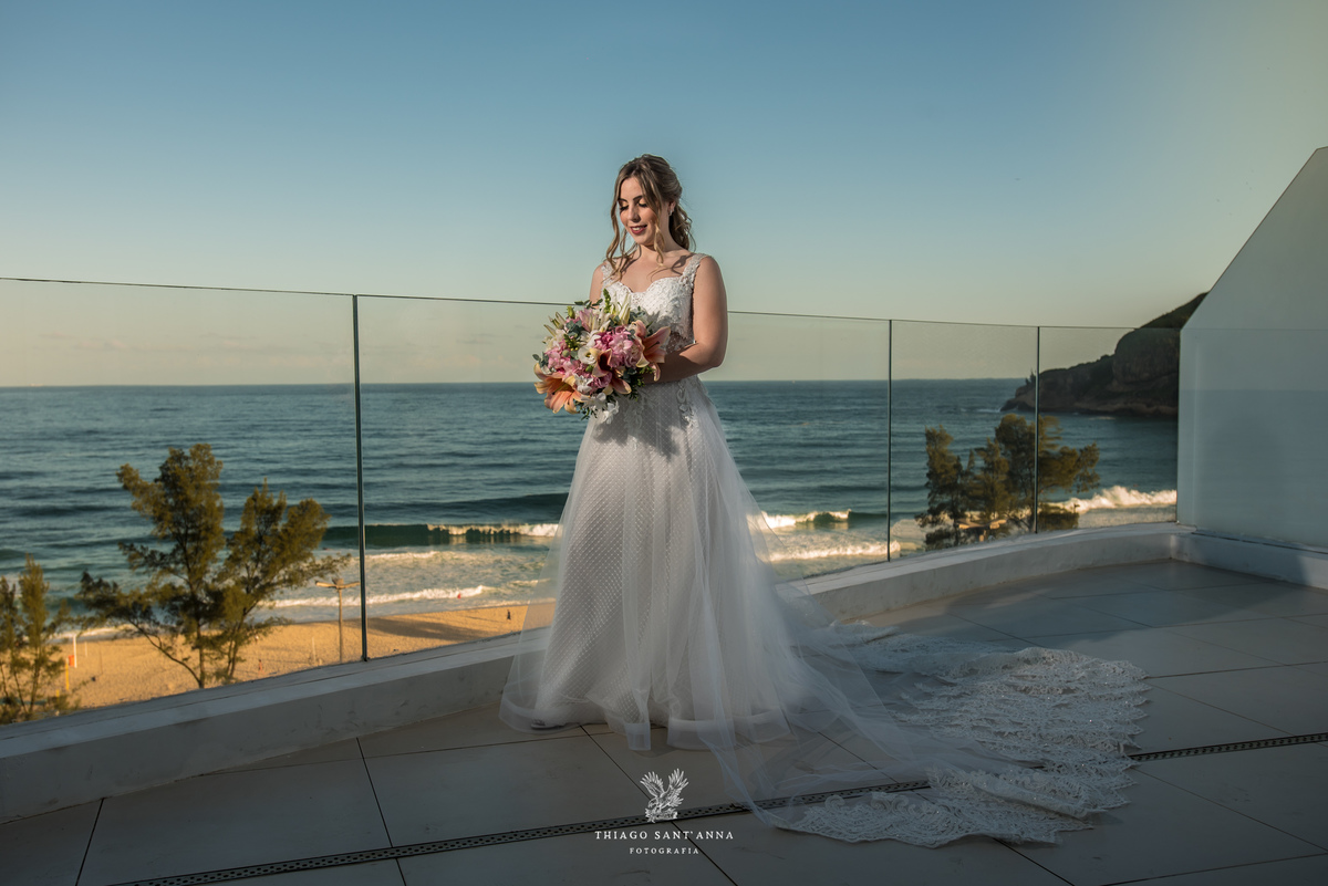 noiva vestido véu buque flores tons de rosa paisagem praia