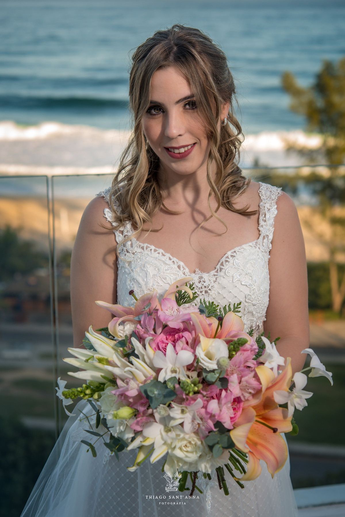noiva vestido véu buque flores tons de rosa paisagem praia
