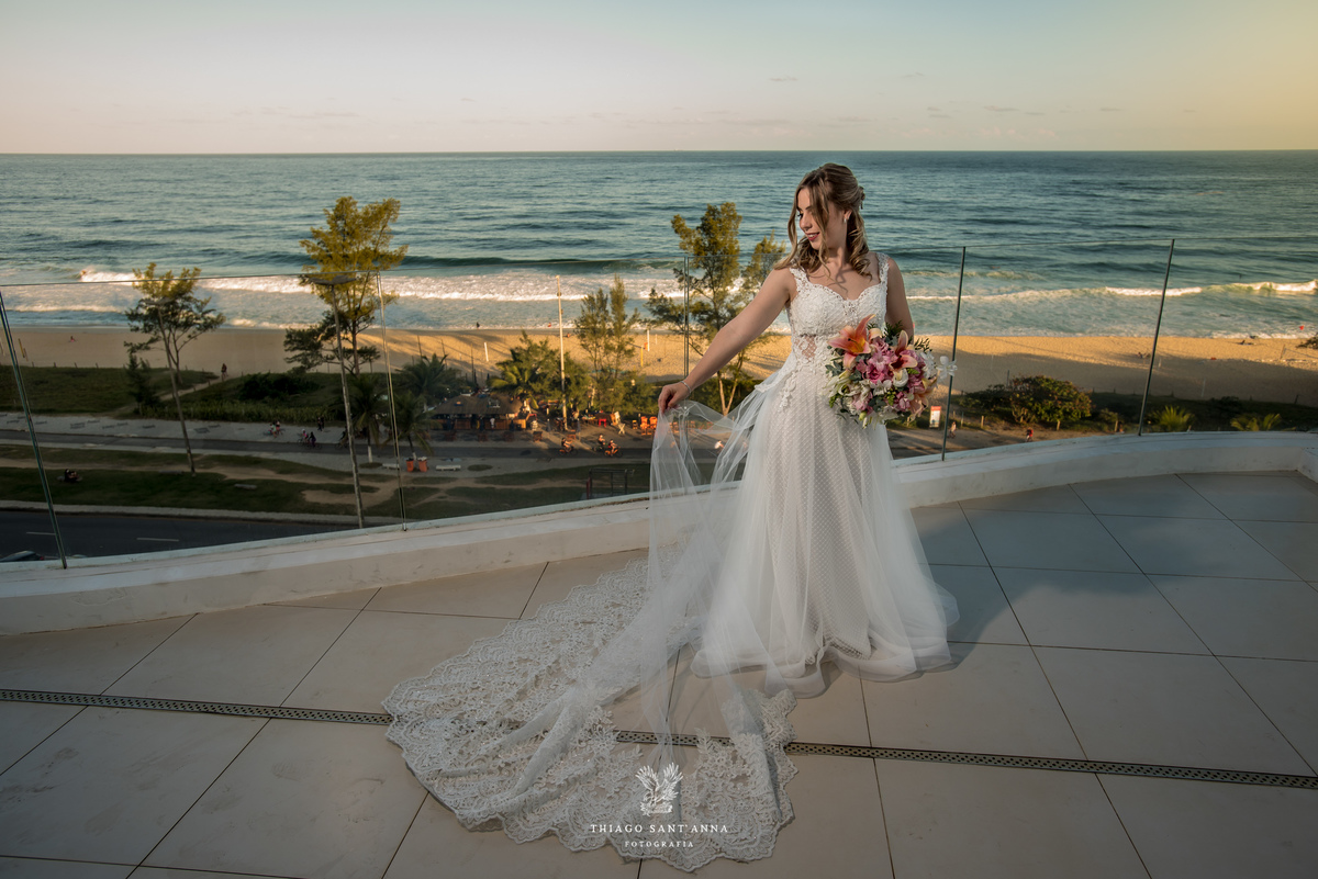 noiva vestido véu buque flores tons de rosa paisagem praia