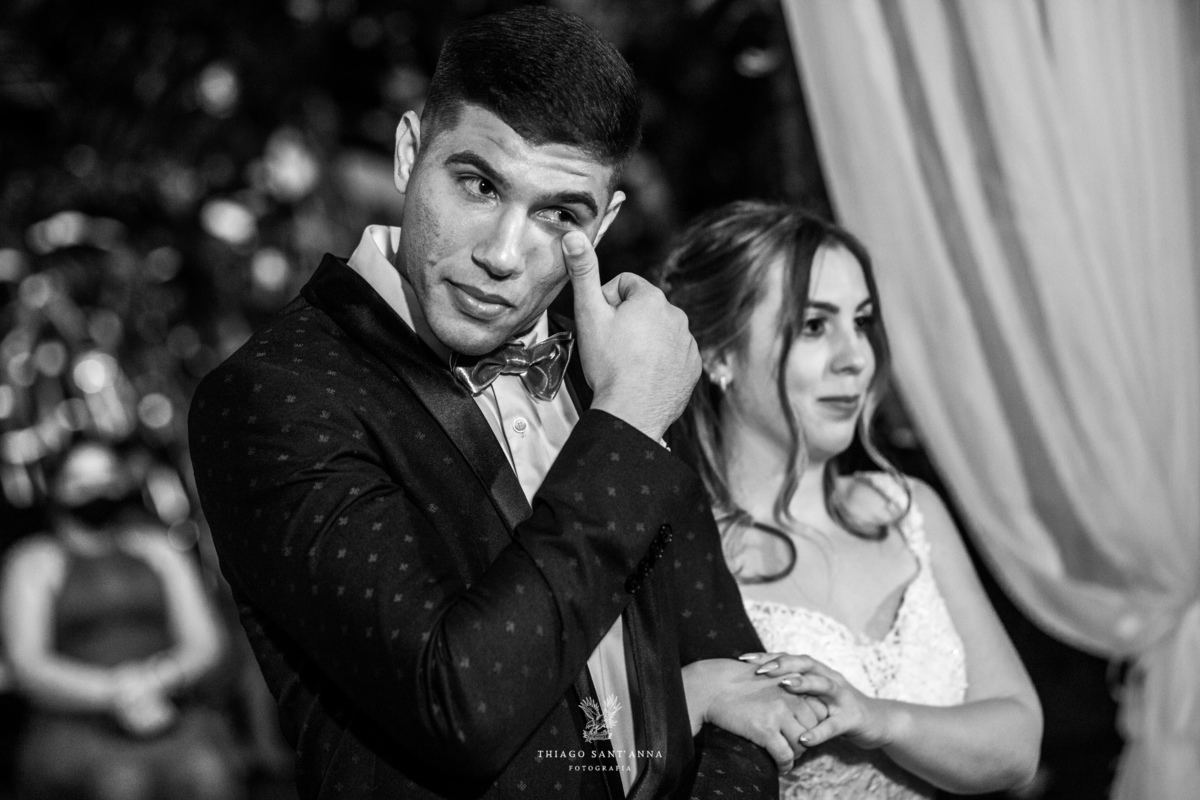 noivos no altar noivo emocionado enxuga as lágrimas preto e branco