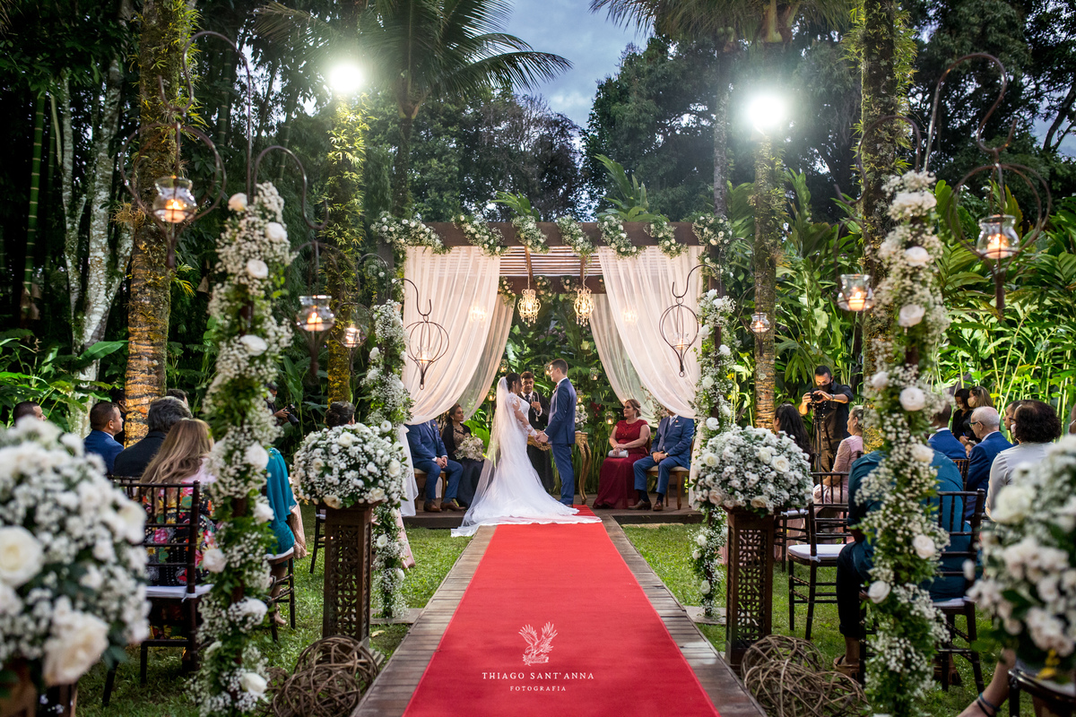 noivos no altar flores brancas tapete vermelho 
