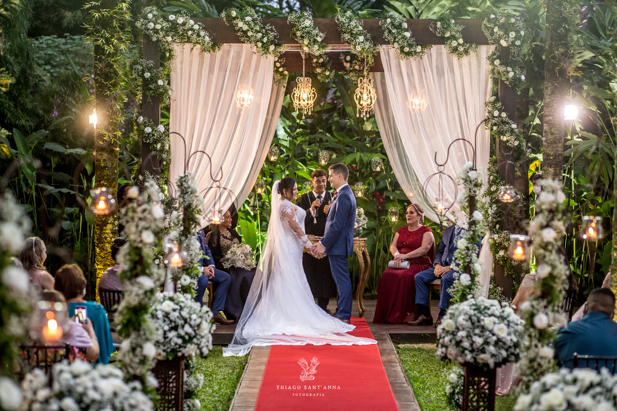 noivos de mãos dadas no altar decoração flores brancas