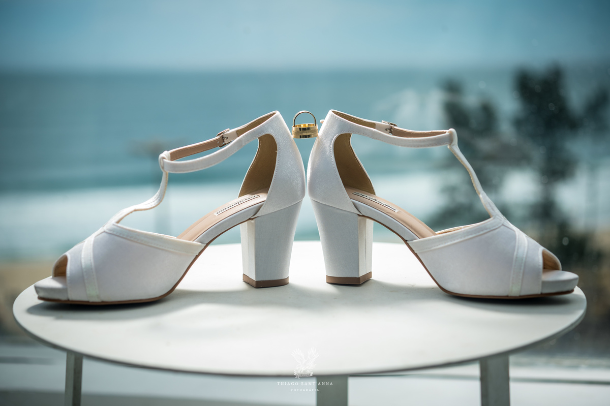 sapatos da noiva branco salto paisagem praia ao fundo