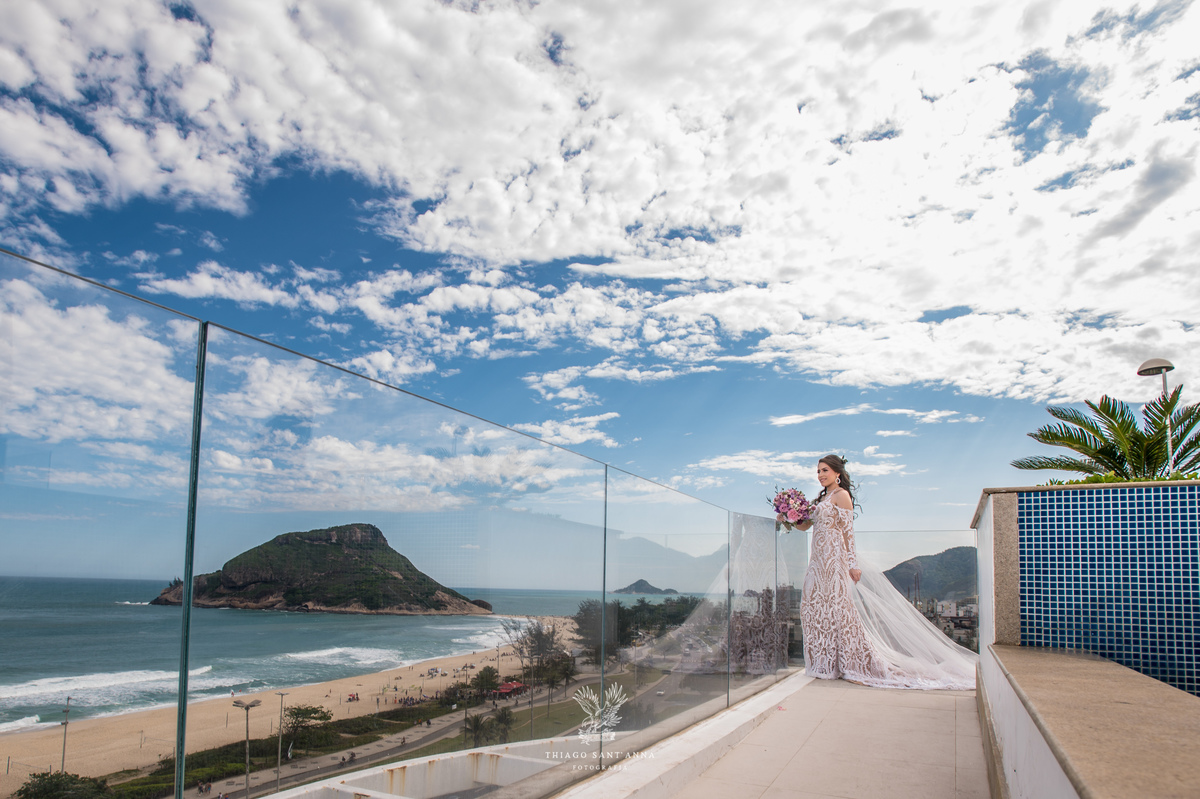 noiva observa paisagem praia vestido renda véu 