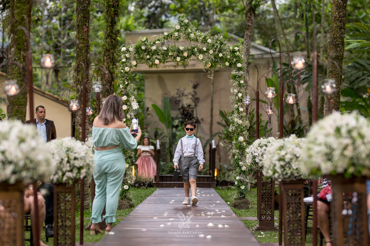 entrada do pajem óculos escuros ambiente externo coqueiros decoração flores brancas 