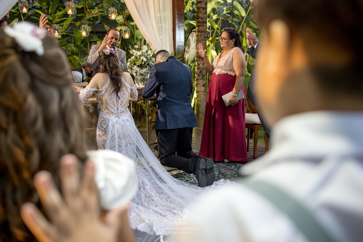 noivos no altar ajoelhados familiares ao redor