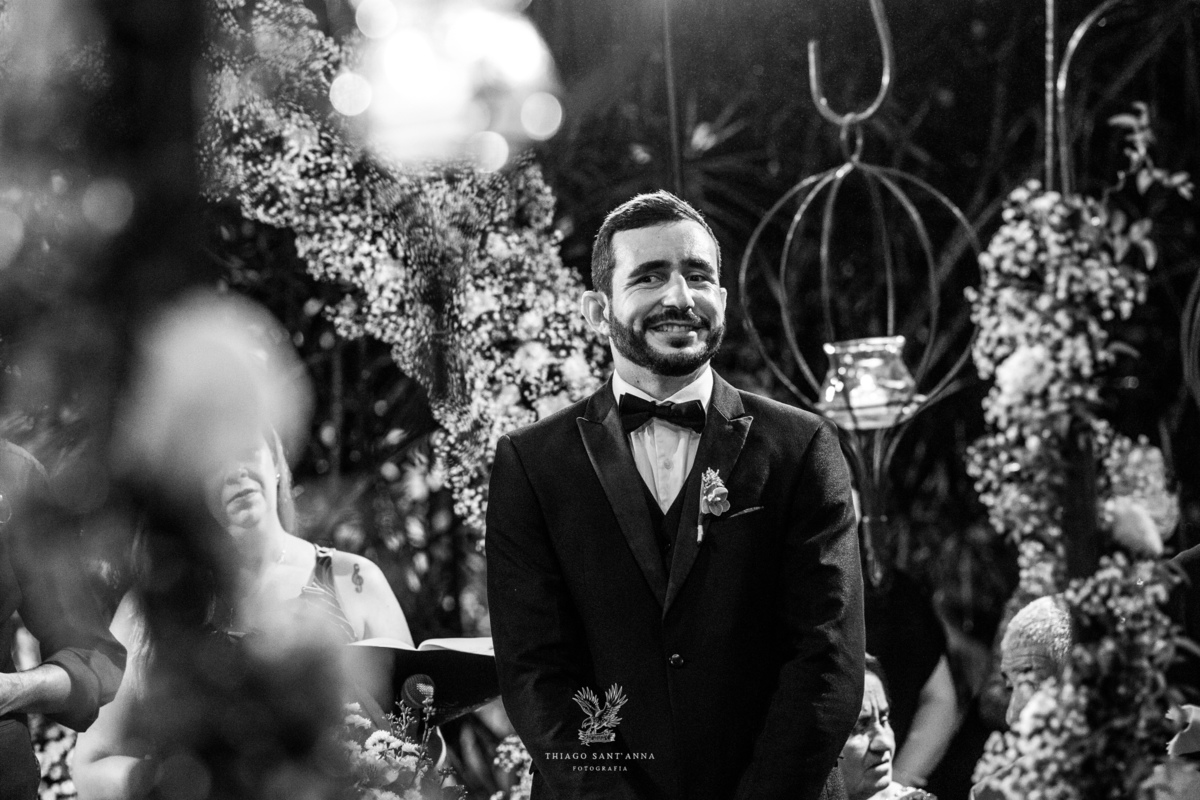 Noivo no altar sorri preto e branco