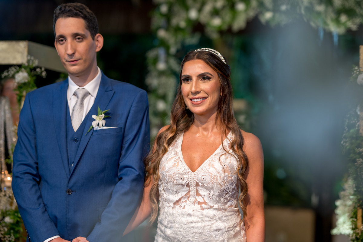 Noiva no altar sorri com noivo