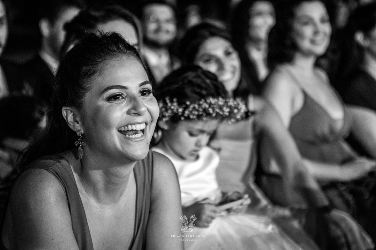 convidados sorrindo observam a cerimônia preto e branco