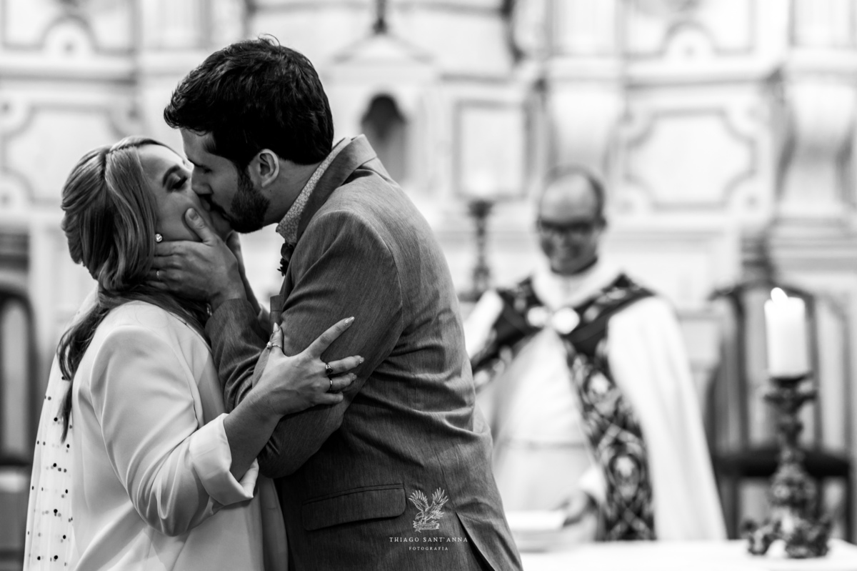 Beijo dos noivos no altar preto e branco