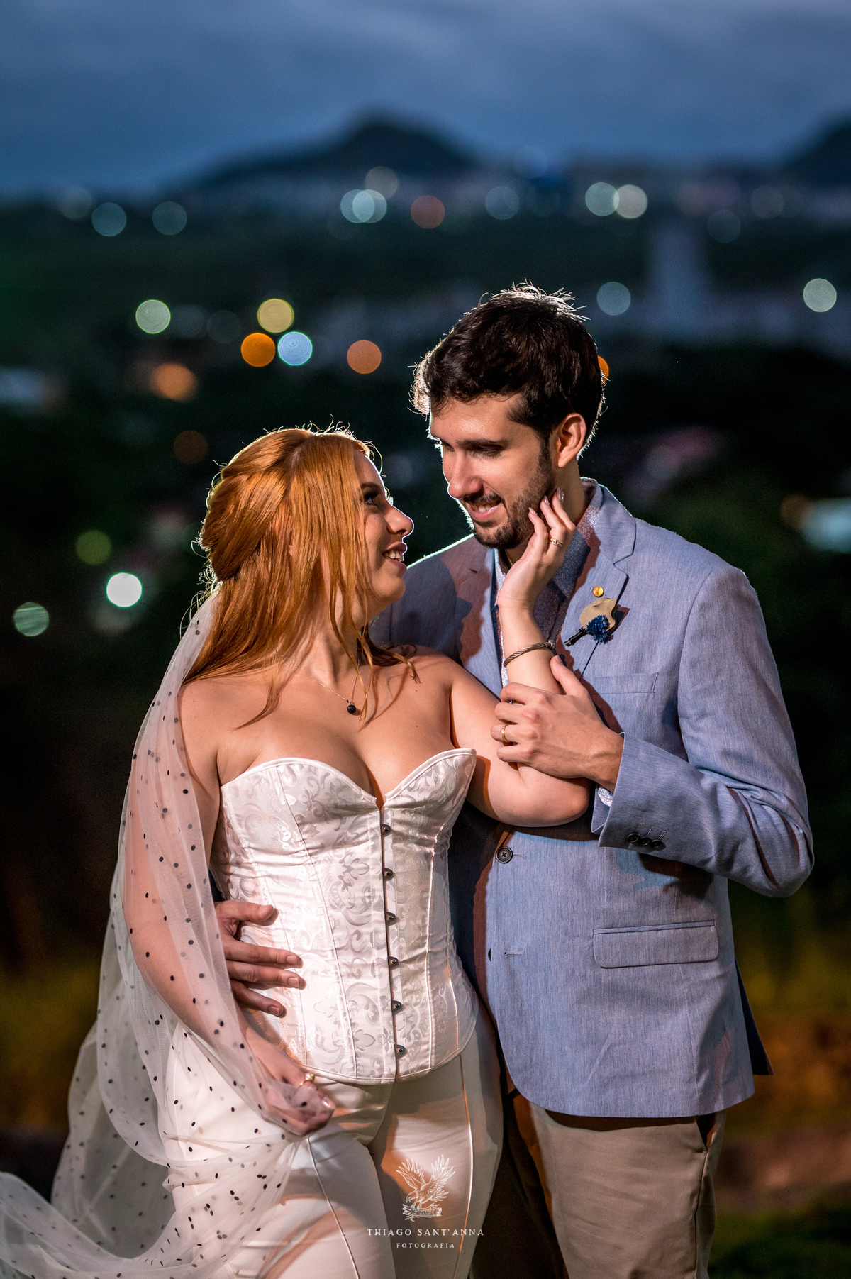 Noivos se abraçam sorrindo noiva toca o rosto do noivo