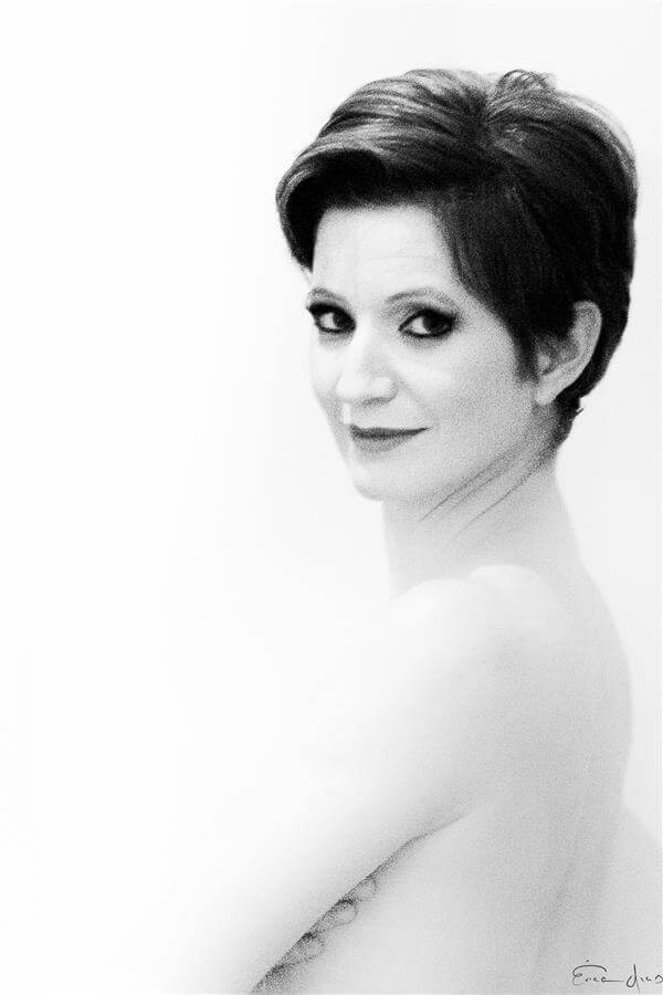 Mulher madura de perfil, com olhar forte captado pelas lentes da talentosa fotógrafa Érica Dias.