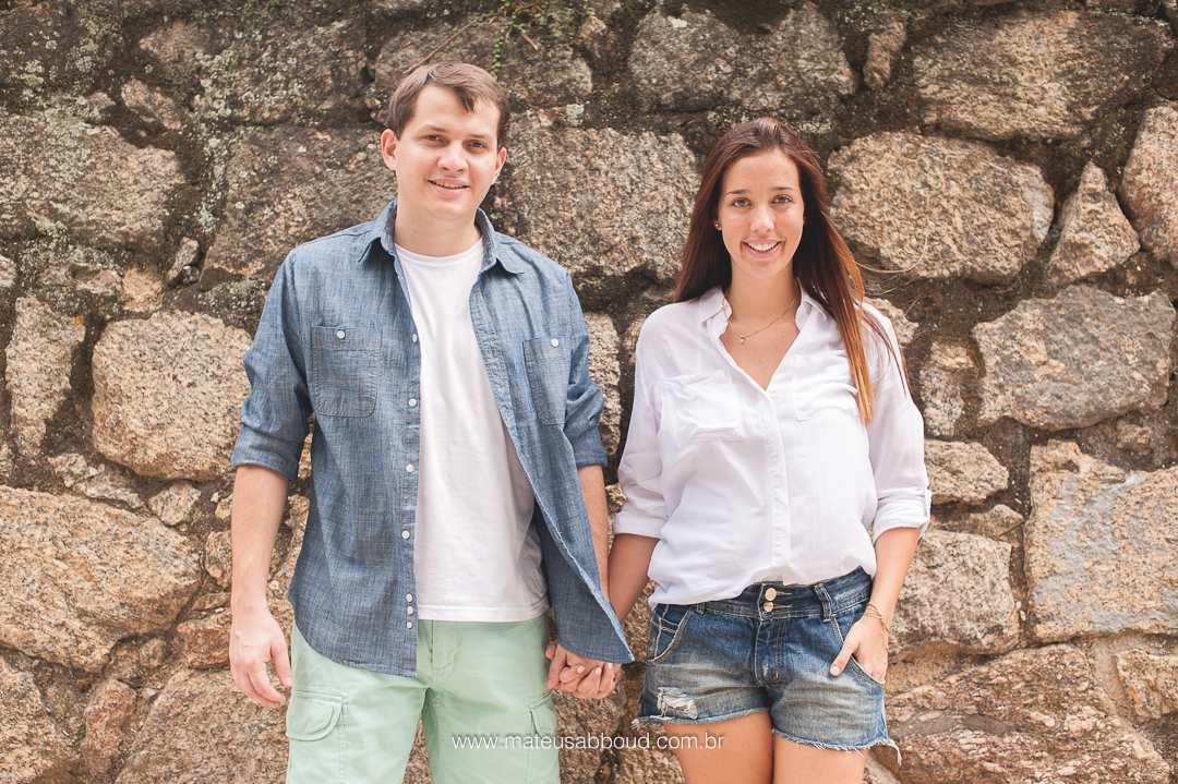 casal de pé e com uma das mãos dadas com o outro.