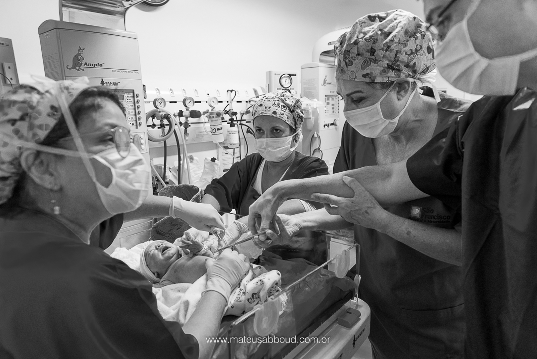 pai cortando o cordão umblical do bebê após o nascimento