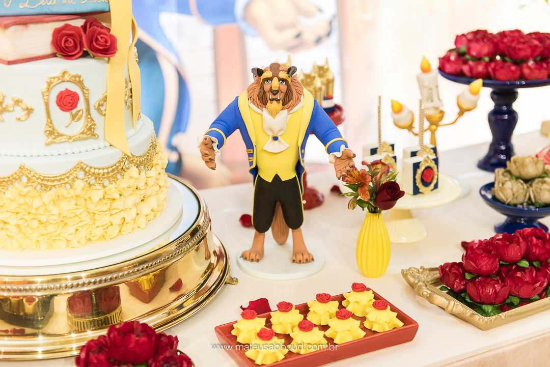 Boneco do personagem Fera sobre a mesa do bolo de aniversário de 1 ano.