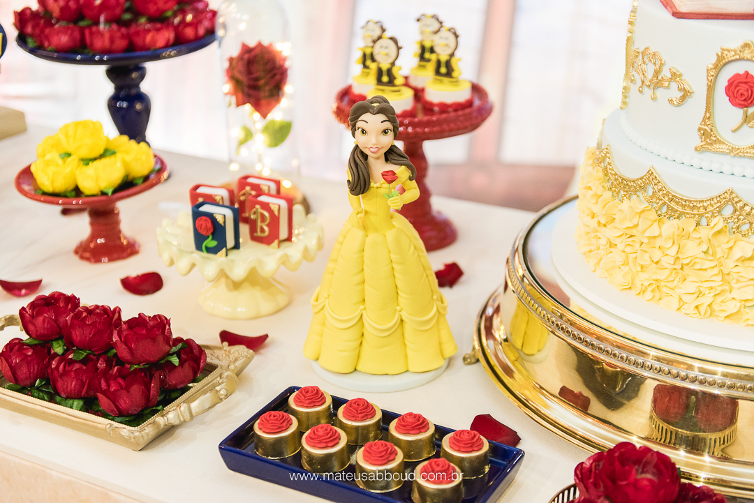 Boneca da personagem Bela sobre a mesa do bolo de aniversário de 1 ano.