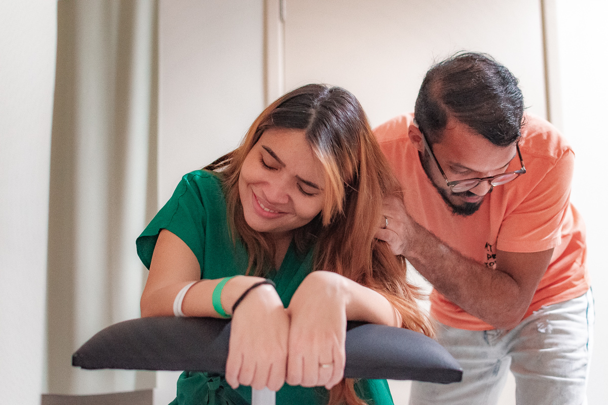 MÃE SORRI ENTRE CONTRAÇÕES EUNQUANTO O PAI LHE FAZ MASSAGEM