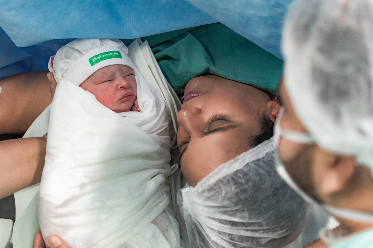 foto de parto em Natal por André Pontes - bebê sendo recebido pelos pais
