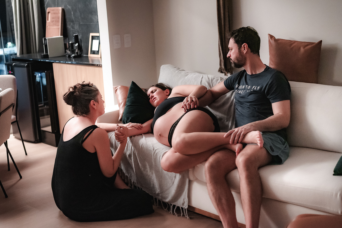 fotografia de parto pelo fotografo de parto andré pontes - irmã e marido dando apoio à mulher em trabalho de parto