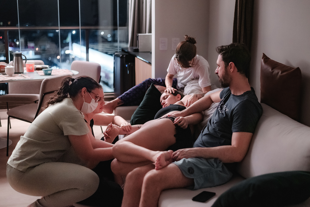 fotografia de parto pelo fotografo de parto andré pontes - doula, enfermeira obstétrica, irmã e marido dando apoio à mulher em trabalho de parto